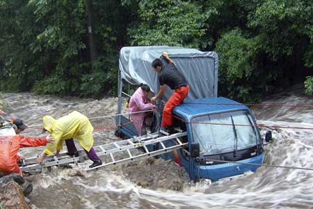 نیروهای امداد در حال نجات سرنشینان یک خودرو پس از باران های سنگین در جاپیونگ کره جنوبی
