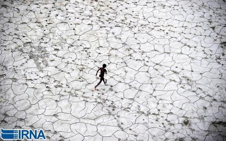 دویدن کودکی خیابانی در رودخانه ای خشک شده در ˈالله آبادˈ هند.