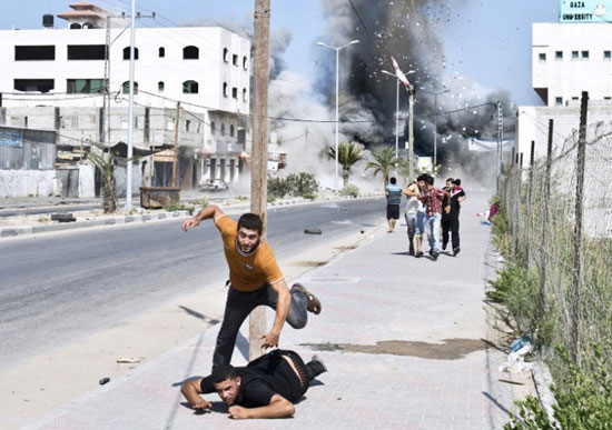 فرار جوانان فلسطینی از بمباران جنگنده های اسرائیلی در غزه. 23 آگوست