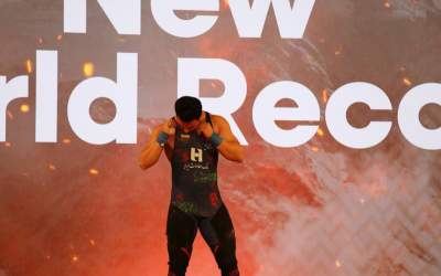 بوسه پسر طلایی وزنه‌برداری بر پرچم ایران